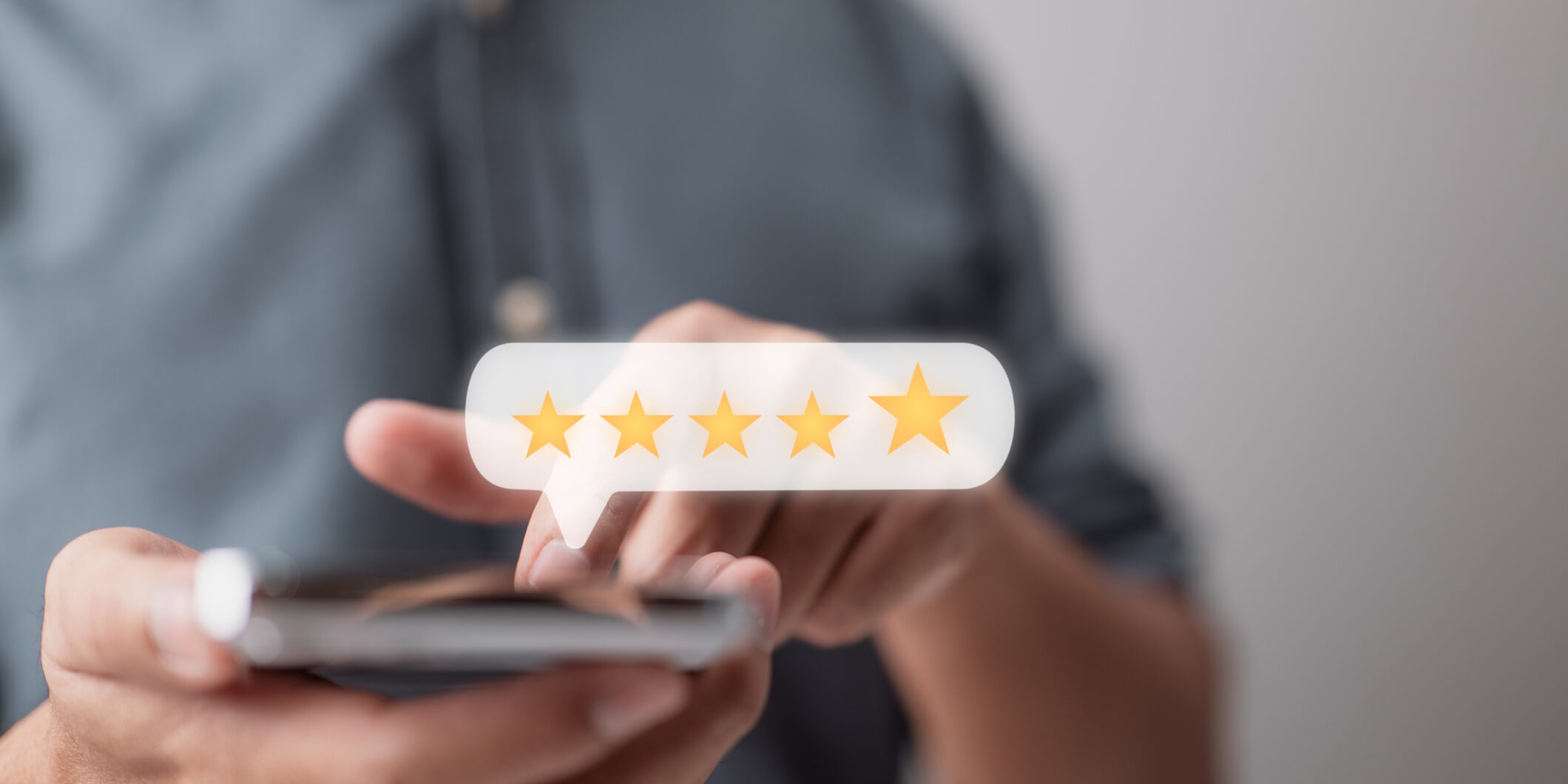A man enters a five-star review on his smartphone in an example of a business leveraging customer service lessons.