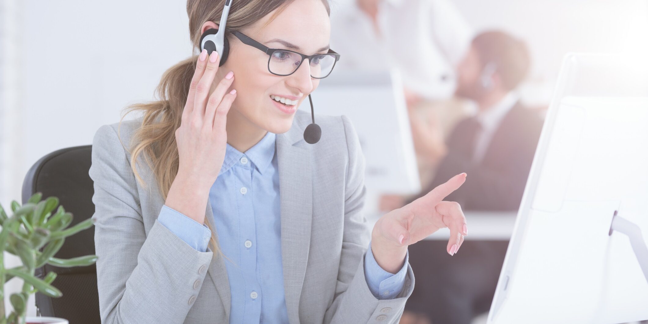 A cheerful answering service speaks to a caller over a headset for customer service spring cleaning blog.