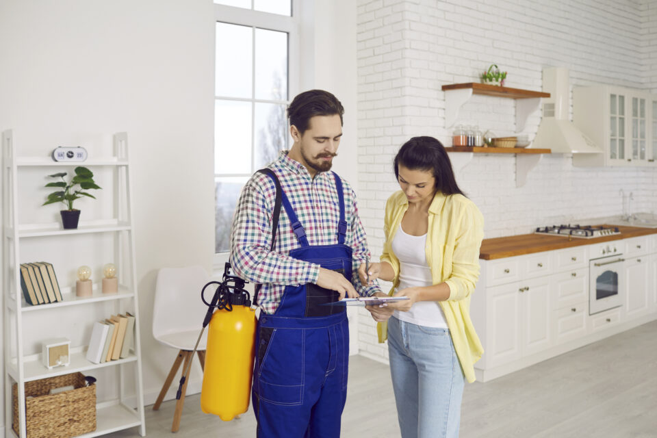 A pest control specialist reviews an invoice with a homeowner for pest-control-answering-service blog.