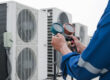 A technician checks an air conditioner for why-your-hvac-company-needs-an-answering-service blog.