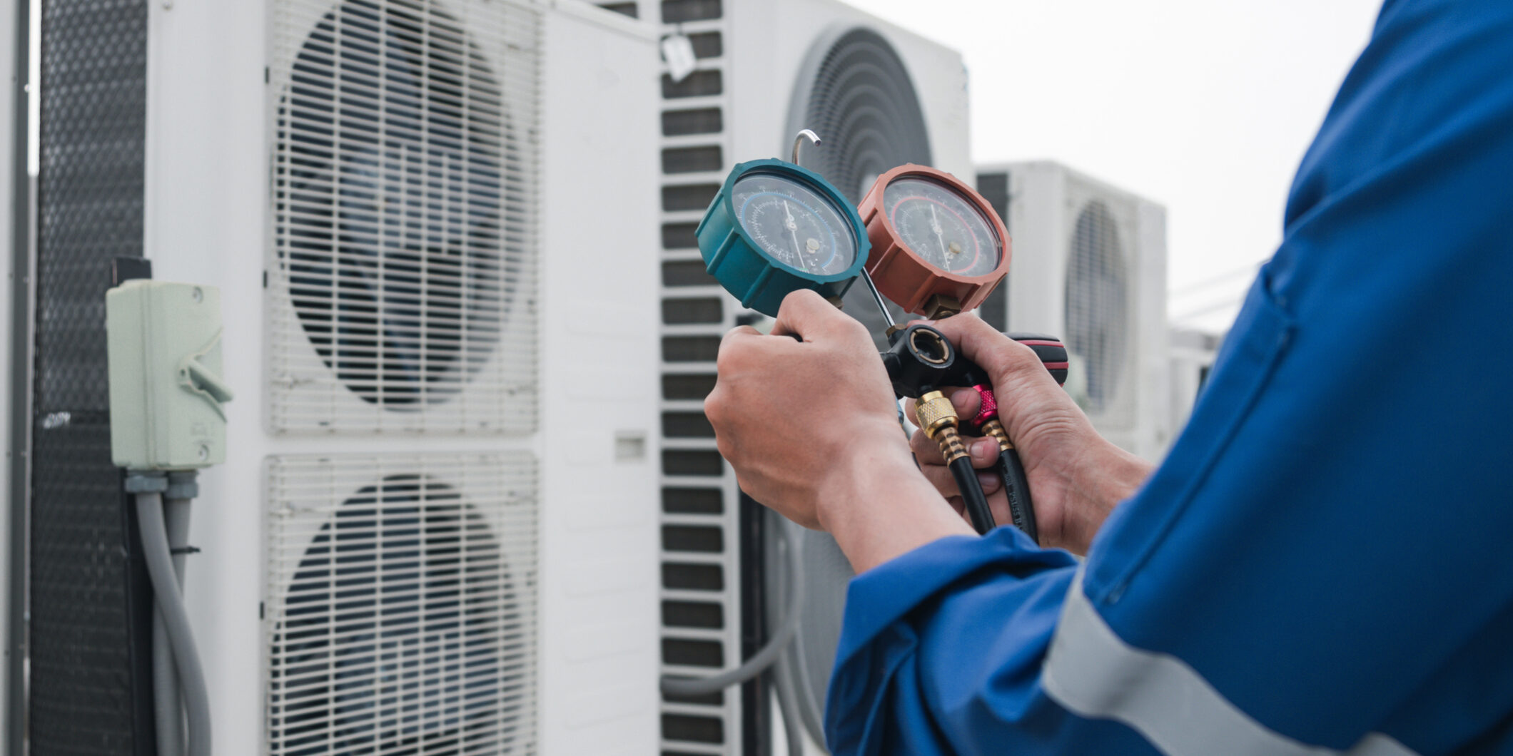 A technician checks an air conditioner for why-your-hvac-company-needs-an-answering-service blog.