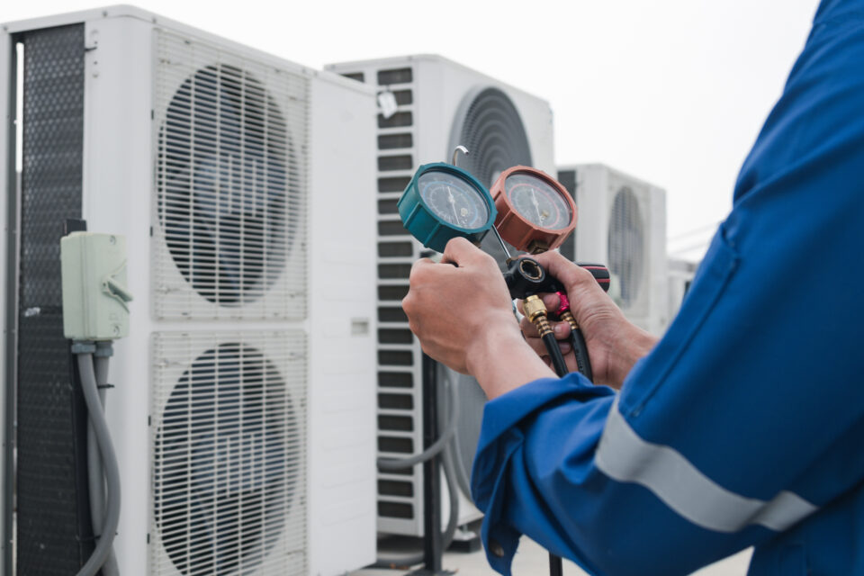A technician checks an air conditioner for why-your-hvac-company-needs-an-answering-service blog.