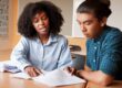 A female tutor helps a young man with an assignment for why-your-tutoring-company-needs-an-answering-service blog.