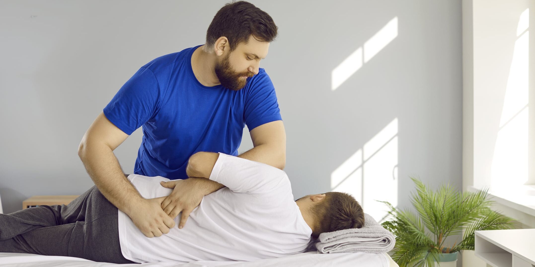 A professional chiropractor adjusts a man's back for why-your-chiropractic-office-needs-an-answering-service.