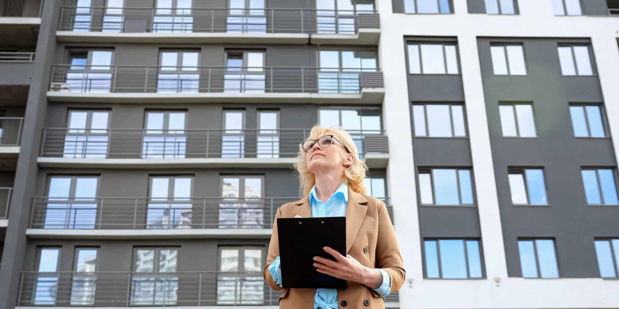 A property manager assesses the outside of a building for why-your-apartment-complex-needs-an-answering-service blog.